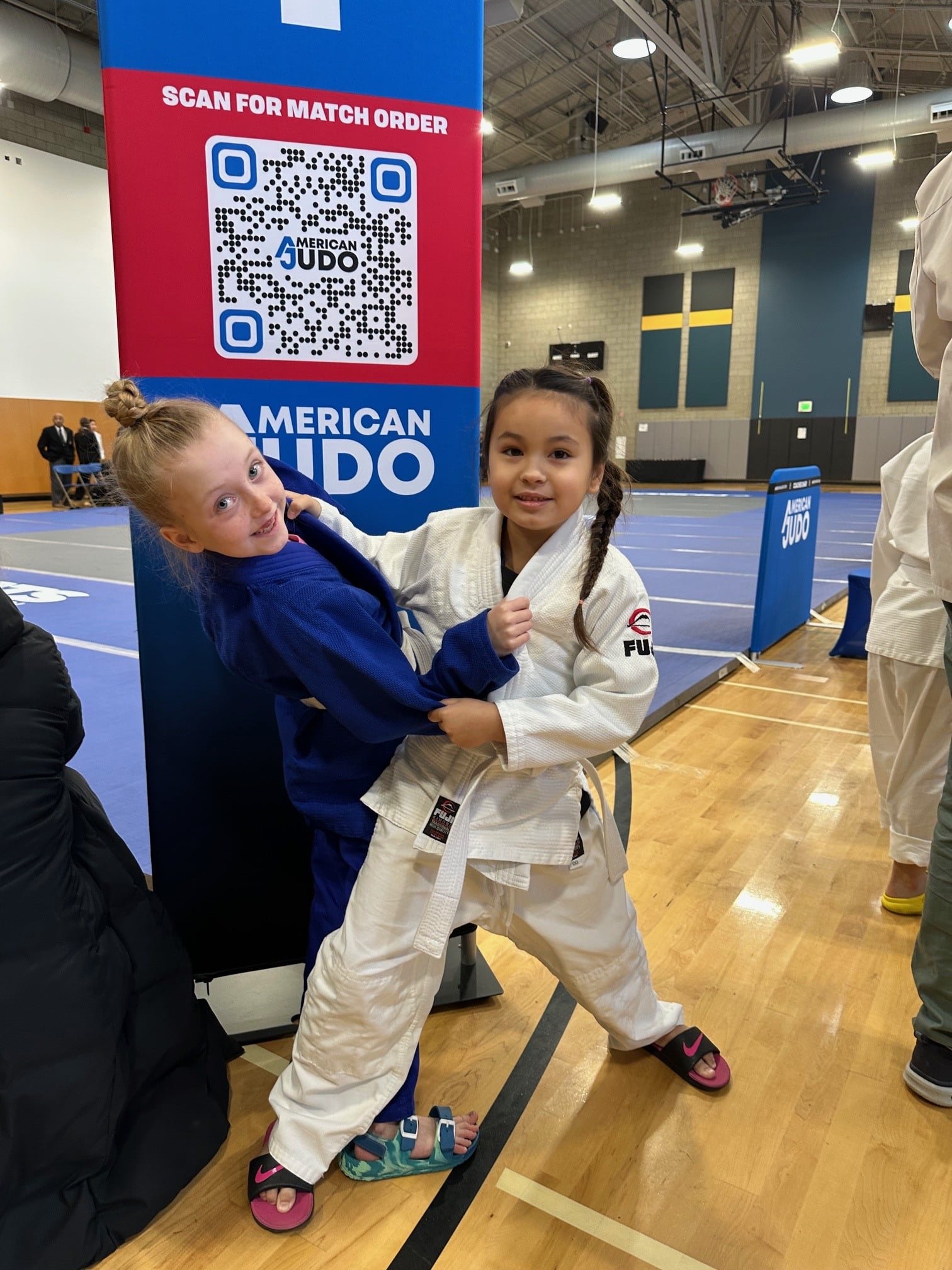 Two young members in judo uniform posing in the middle of a grapple