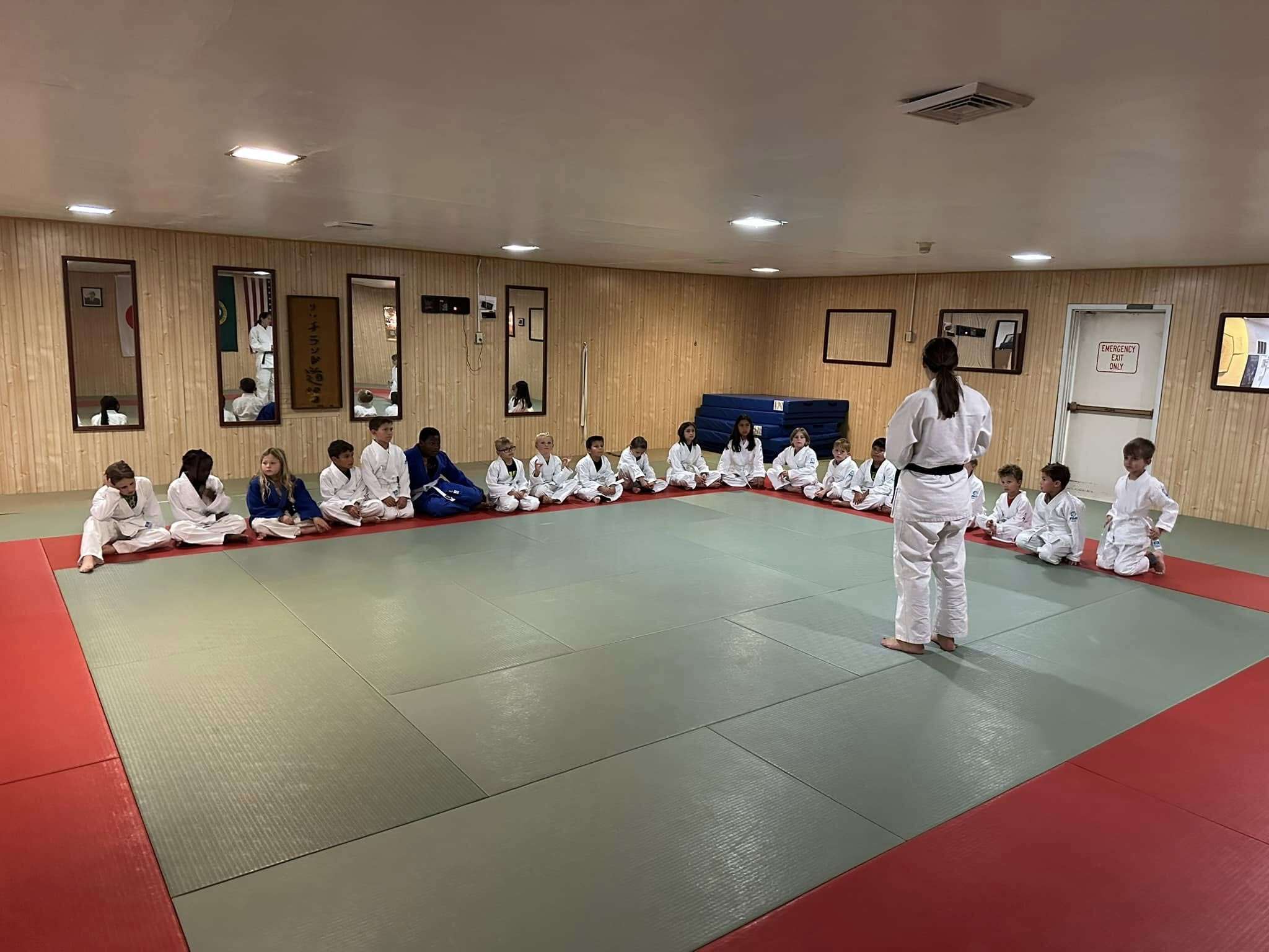 Instructor stands in front of junior judo class